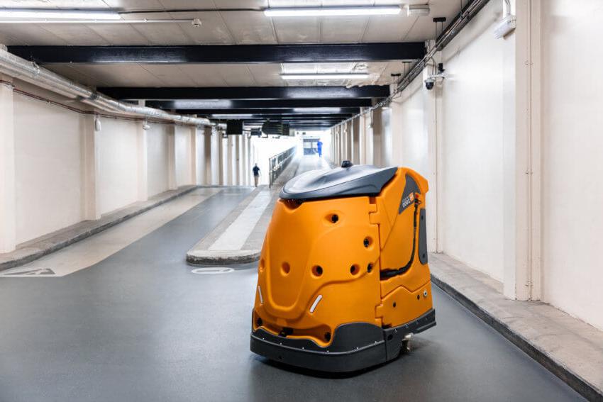 Yellow robotic cleaner patrolling a utility corridor